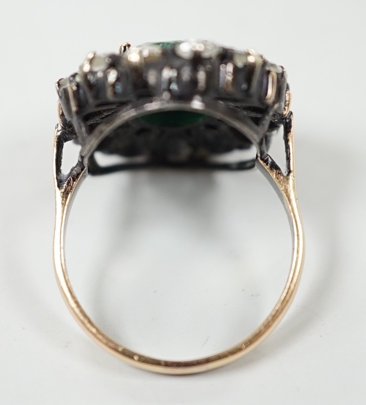 An Indian yellow and white metal, emerald and rose cut diamond set oval cluster dress ring, size N, gross weight 6.3 grams.
